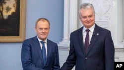 Poland's Prime Minister Donald Tusk, left, and Lithuania's President Gitanas Nauseda pose for the media prior to their meeting at the Presidential palace in Vilnius, Lithuania, March 4, 2024.
