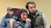 Uzbek blogger Olimjon Haydarov, right, puts his arm around his mother after the verdict in a Ferghana criminal court, Uzbekistan, Dec. 1, 2023.