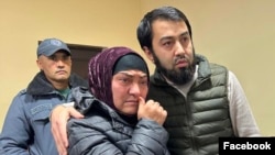 Uzbek blogger Olimjon Haydarov, right, puts his arm around his mother after the verdict in a Ferghana criminal court, Uzbekistan, Dec. 1, 2023.