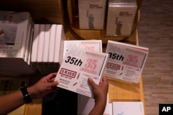 一名顾客在香港一家书店里拿起前香港剧团“六四舞台”为纪念八九六四出版的剧本《5月35日》。（2023年6月2日）