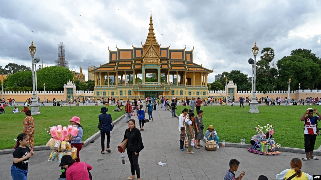 រូបឯកសារ៖ ពលរដ្ឋលំហែកាយនៅមុខព្រះរាជបរមរាជវាំង ក្នុងរាជធានីភ្នំពេញ កាលពីថ្ងៃទី ២៤ ខែកក្កដា ឆ្នាំ ២០២៣។ (Photo by TANG CHHIN Sothy / AFP)