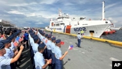 Philippine Coast Guard personnel wave Vietnamese and Philippine flags to welcome a Vietnam Coast Guard ship in Manila, Philippines, Aug. 5, 2024.