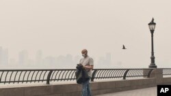 A man walks wearing a mask as an air quality health advisory was issued in New York on June 7, 2023. The smoke drifted into the city from wildfires in Canada.