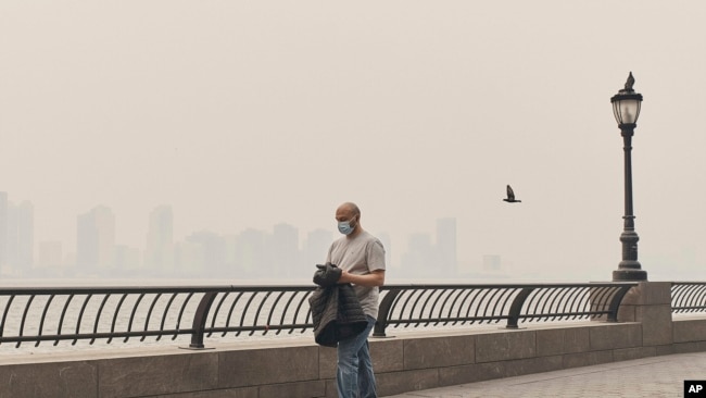 A man walks wearing a mask as an air quality health advisory was issued in New York on June 7, 2023. The smoke drifted into the city from wildfires in Canada.