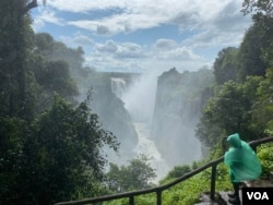 A tourist takes photos of Victoria Falls from the Zimbabwean side. (Columbus Mavhunga/VOA)