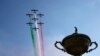 Tim aerobatik Angkatan Udara Italia &quot;Frecce Tricolori&quot; dengan asap warna bendera Italia terbang di atas patung besar piala saat upacara pembukaan Piala Ryder di Klub Golf Marco Simone di Guidonia Montecelio, Italia. (AP)&nbsp;