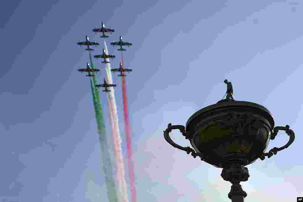A fly-past by the Italian Air Force team Frecce Tricolori with smoke the color of the Italian flag flies over a large statue of the trophy during the Ryder Cup opening ceremony at the Marco Simone Golf Club in Guidonia Montecelio, Italy.