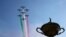 Tim aerobatik Angkatan Udara Italia &quot;Frecce Tricolori&quot; dengan asap warna bendera Italia terbang di atas patung besar piala saat upacara pembukaan Piala Ryder di Klub Golf Marco Simone di Guidonia Montecelio, Italia. (AP)&nbsp;