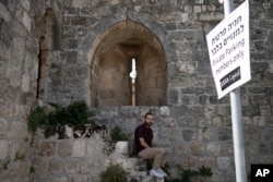 Community leader Hagop Djernazian sits on the edge of a parking lot that is part of a contentious lease deal in the Armenian Quarter in the Old City of Jerusalem, May 30, 2023.