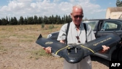 A technician from RoboCare prepares to fly a drone over an agricultural domain to scan the trees from the air and assess their hydration levels, soil quality and overall health, to prevent irreversible damage, in the region of Nabeul, Aug. 30, 2023. 