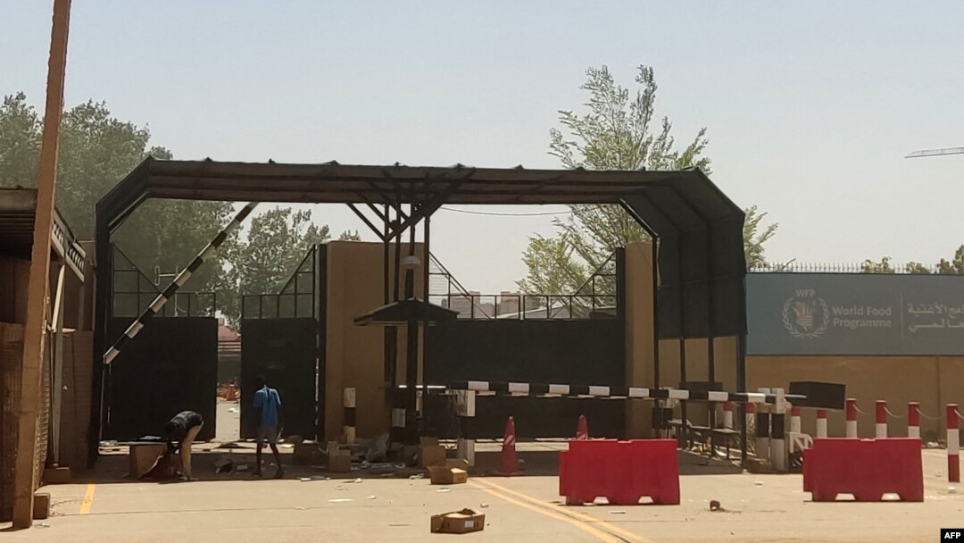 FILE - Men inspect boxes outside a warehouse for the World Food Program (WFP) in Khartoum on May 13, 2023.