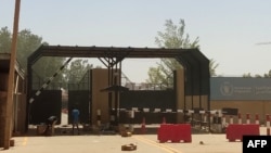 FILE - Men inspect boxes outside a warehouse for the World Food Program (WFP) in Khartoum on May 13, 2023.