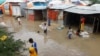 Somali children wade through floodwaters outside their makeshift shelters following heavy rains at the Al Hidaya camp for the internally displaced people on the outskirts of Mogadishu, Somalia, Nov. 6, 2023