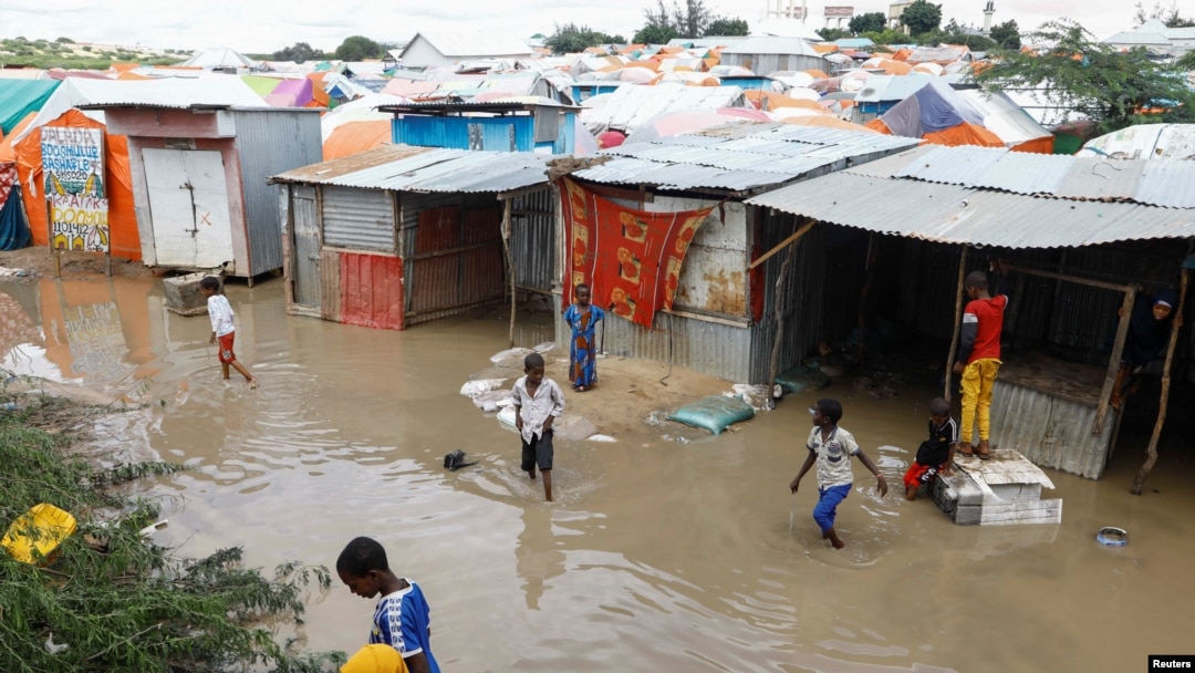Somali children wade through floodwaters outside their makeshift shelters following heavy rains at the Al Hidaya camp for the internally displaced people on the outskirts of Mogadishu, Somalia, Nov. 6, 2023