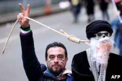 Seorang demonstran memegang boneka gantung yang melambangkan Pemimpin Tertinggi Iran saat protes mendukung gerakan perlawanan Iran di Brussels pada 20 Februari 2023. (Foto: AFP)