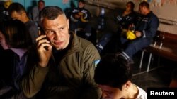 FILE - Kyiv Mayor Vitali Klitschko talks on the phone as he takes cover inside a bomb shelter with with responders and local residents during an air raid alert, amid Russia's attacks on Ukraine, in Kyiv, June 1, 2023.