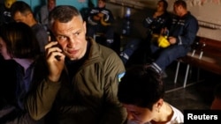 FILE - Kyiv Mayor Vitali Klitschko talks on the phone as he takes cover inside shelter with with responders and local residents during an air raid alert, amid Russia's attacks on Ukraine, in Kyiv, June 1, 2023.