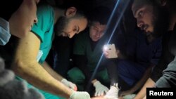 加沙地带北部印度尼西亚医院的医务人员用手机照明救治伤员。（2023年11月16日）