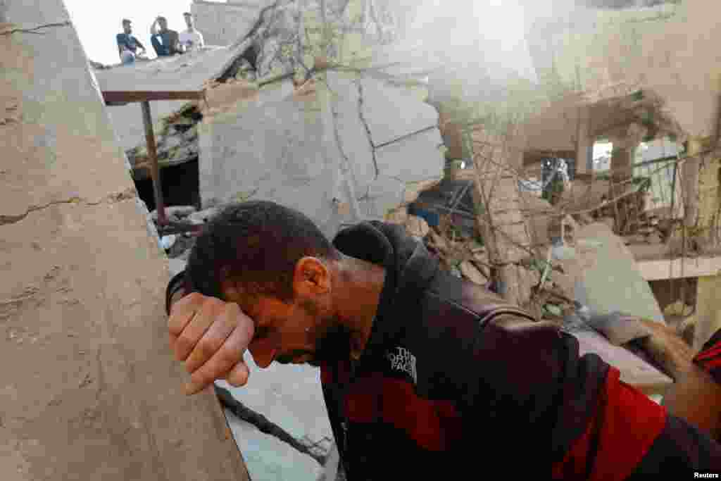 A Palestinian man reacts, as people search for survivors in the aftermath of Israeli strikes, in Khan Younis, in the southern Gaza Strip.