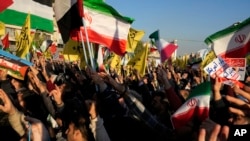 Iranian demonstrators chant slogans as they wave Iranian and Palestinian flags in a pro-Palestinian rally at Islamic Revolution Square in Tehran, Iran, Nov. 18, 2023.