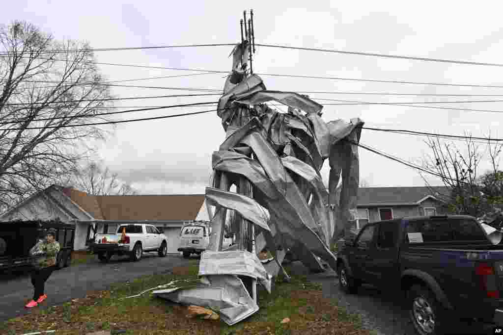 Металниот покрив од блиската црква е обвиткан околу столб за помош во Кларксвил, Тенеси. Торнадата предизвикаа катастрофални штети во Средниот Тенеси.
