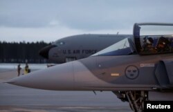 Jet tempur JAS Gripen Swedia berdiri di samping pesawat AS di Pangkalan Udara Kallax, Swedia, 4 Maret 2024. REUTERS/Leonhard Foeger