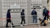 军装警员牵着警犬监察进入西九龙裁判法院大楼，旁听香港壹传媒创办人黎智英国安案的市民 (美国之音/汤惠芸)