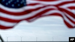 FILE - The five turbines of America's first offshore wind farm, owned by the Danish company, Orsted, are seen from a tour boat flying the American flag off the coast of Block Island, RI, Oct. 17, 2022. 