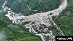 In this aerial photo released by Xinhua News Agency, the impact of flash floods and mudslides can be seen near Ridi Village, Kangding City, Garze Tibetan Autonomous Prefecture in southwestern China's Sichuan Province, Aug. 4, 2024. 