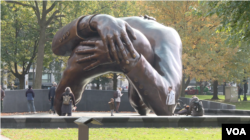 "The Embrace," sebuah patung perunggu karya seniman Hank Willis Thomas, menggambarkan pelukan antara Martin Luther King Jr. dan istrinya Coretta Scott King, di Boston Common, Massachusetts, 7 November 2023. (Adam Greenbaum/VOA)