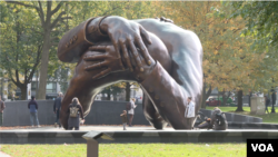 "The Embrace," a bronze sculpture by artist Hank Willis Thomas, depicts an embrace between Martin Luther King Jr. and his wife Coretta Scott King, in Boston Common. (Photo Adam Greenbaum/VOA)