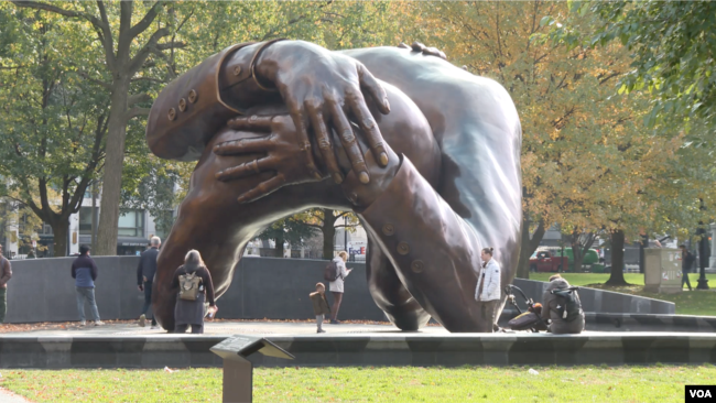 "The Embrace," a bronze sculpture by artist Hank Willis Thomas, depicts an embrace between Martin Luther King Jr. and his wife Coretta Scott King, in Boston Common. (Photo Adam Greenbaum/VOA)