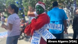 Trabajadores activos y jubilados de Venezuela, uno de ellos disfrazado del personaje el Grinch, se manifiestan por mejores salarios, el pago completo de aguinaldos y pensiones más "dignas" en Caracas, el 9 de noviembre de 2023.