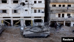 Izraelski tenk manevrira kroz ruševine, usred tekuće kopnene invazije na palestinsku islamističku skupinu Hamas u sjevernom Pojasu Gaze, 8. studenog 2023. REUTERS/Ronen Zvulun