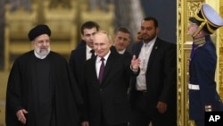 Presiden Rusia Vladimir Putin, tengah, menyambut Presiden Iran Ebrahim Raisi, kiri, untuk pembicaraan di Kremlin di Moskow, 7 Desember 2023. (Pool Photo via AP)