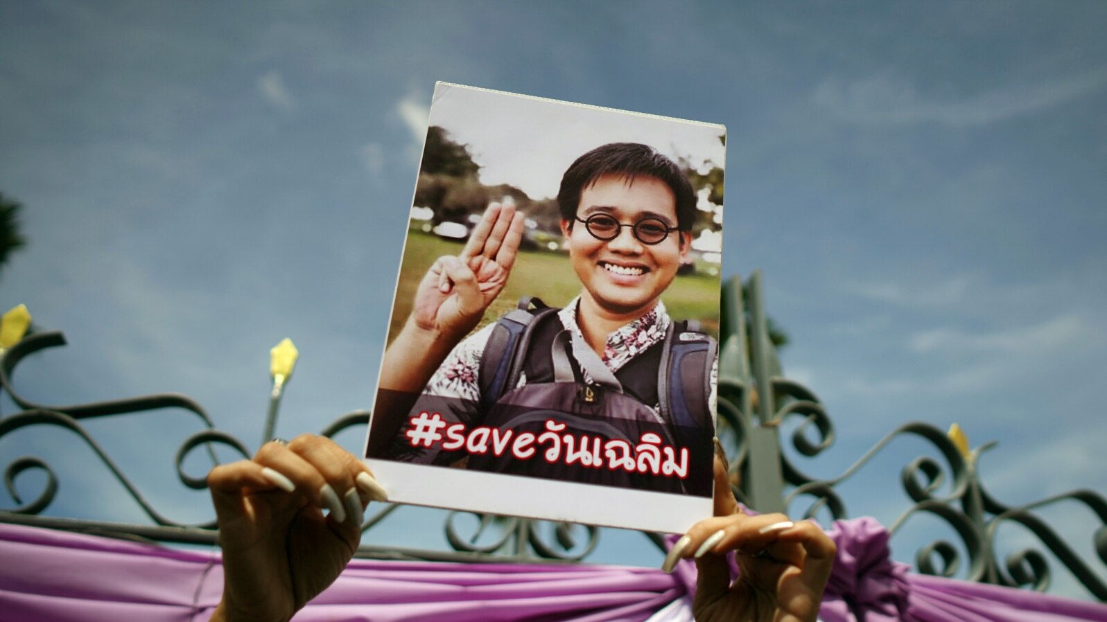 FILE - An activist holds up a picture of abducted Thai activist Wanchalearm Satsaksit as people gather in support of him during a protest calling for an investigation in front of the Government house in Bangkok, Thailand, June 12, 2020.