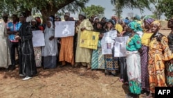 Les parents des filles de Chibok enlevées tiennent des photos de leurs filles lors d'une commémoration en 2019, cinq ans après leur enlèvement par Boko Haram.