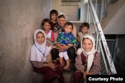 La organización sin fines de lucro Too Young to Wed convenció al anciano esposo de Parwana Malik para que la devolviera a su familia. Parwana, al frente a la derecha, está entre siete hermanas y un hermano, de los cuales no todos aparecen en la foto.