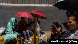 ARCHIVO - Cientos de personas de barrios pobres esperan frente a un centro de detención en Caracas buscando información sobre sus familiares que fueron arrestados durante las protestas contra los resultados de las elecciones, el 1 de agosto de 2024.