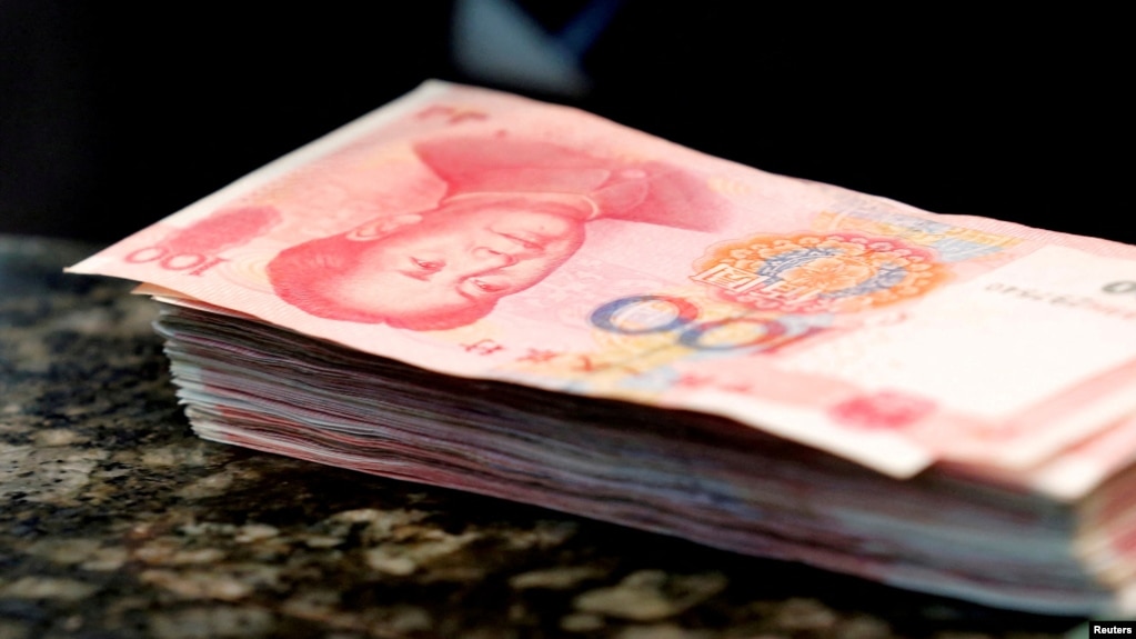 FILE - Chinese 100 yuan banknotes are seen on a counter of a branch of a commercial bank in Beijing, March 30, 2016.
