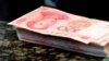 FILE - Chinese 100 yuan banknotes are seen on a counter of a branch of a commercial bank in Beijing, March 30, 2016. 