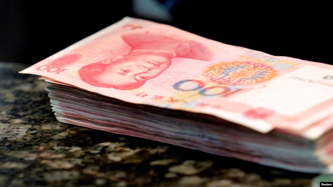 FILE - Chinese 100 yuan banknotes are seen on a counter of a branch of a commercial bank in Beijing, March 30, 2016. 