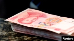 FILE - Chinese 100 yuan banknotes are seen on a counter of a branch of a commercial bank in Beijing, March 30, 2016. 