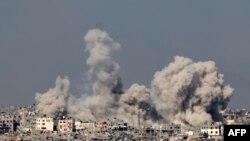 গাজা ভূখণ্ডের সীমান্তের কাছে ইসরাইলের দক্ষিণাঞ্চল থেকে তোলা ছবিতে উত্তর গাজায় ইসরাইলের হামলার সময় ভবনগুলোর ওপরে ধোঁয়া উড়তে দেখা যাচ্ছে। ৮ ডিসেম্বর, ২০২৩। 