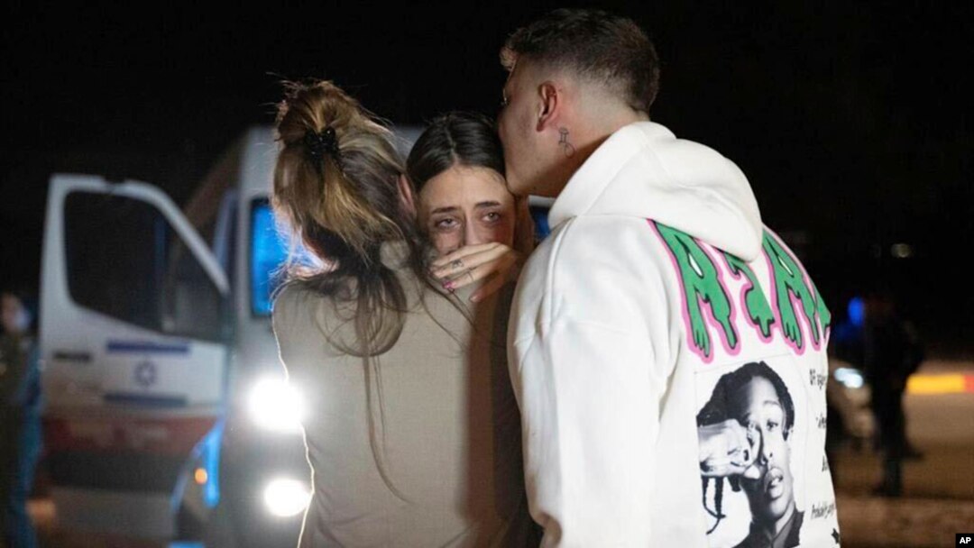 Maya Shem, center, is greeted by her mother and brother as she arrives at the Hatzerim Air Base, Nov. 30, 2023, in Israel after being released from Hamas captivity. (GPO/Handout via AP)