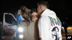 Maya Shem, center, is greeted by her mother and brother as she arrives at the Hatzerim Air Base, Nov. 30, 2023, in Israel after being released from Hamas captivity. (GPO/Handout via AP)