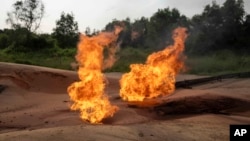 ARCHIVO - Una bengala ardiendo es visible en un área de extracción de petróleo ubicada en Moanda, República Democrática del Congo, el 23 de diciembre de 2023.