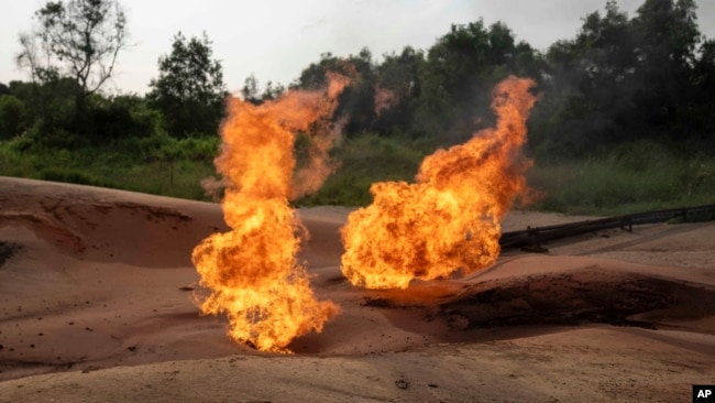 FILE - A burning flare is visible at an oil extraction area located in Moanda, Democratic Republic of the Congo, Dec. 23, 2023.