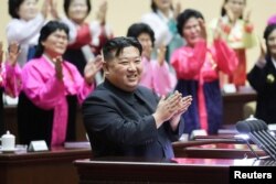 Pemimpin Korea Utara Kim Jong-un bertepuk tangan pada Pertemuan Nasional ke-5 Para Ibu di Pyongyang dalam gambar yang dirilis oleh Kantor Berita Pusat Korea, 4 Desember 2023. (KCNA via REUTERS)