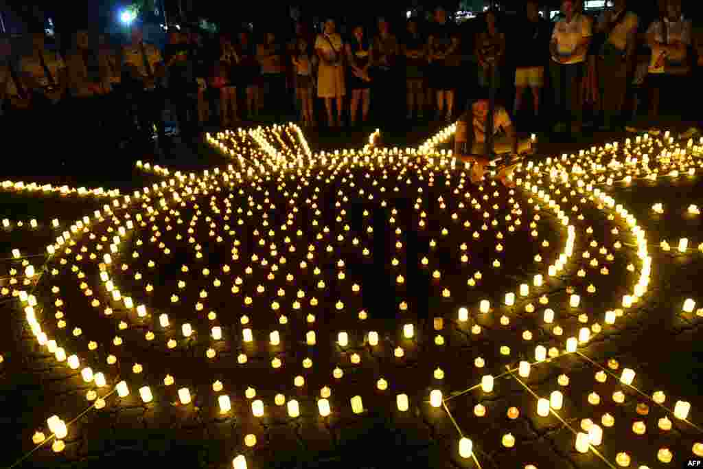 People place LED candles during a vigil in memory of Super Typhoon Haiyan victims on the 10th anniversary of the disaster at a park in Tacloban city, Leyte province.